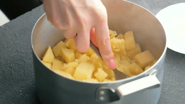  Woman's Hand Making Mashed Potato Use Fork in Saucepan. Cooking Mashed Potatoes.