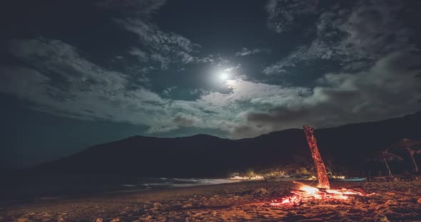 Thailand Beach Night Timelapse Fire at Sand Ocean Shore with Mountain Silhouette at Moon Stars Sky