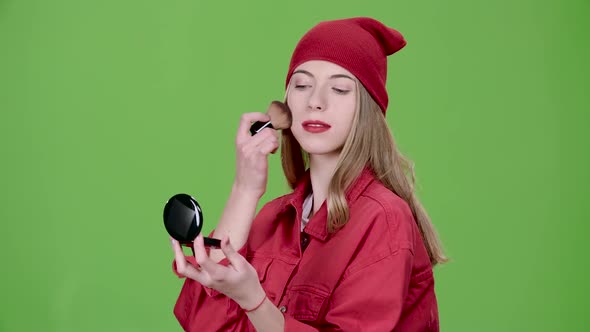 Girl Is Applying Makeup with a Brush. Green Screen. Slow Motion alt