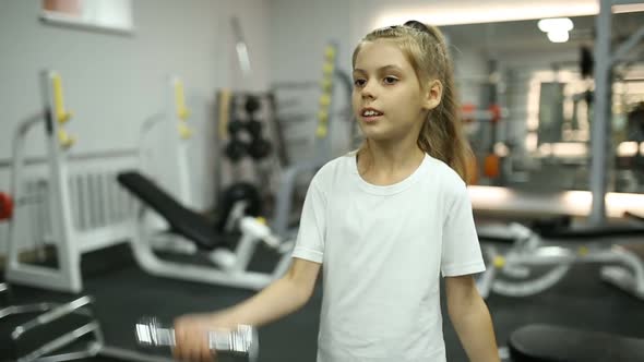 Girl with Dumbbells in the Gym