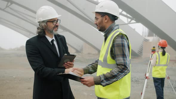 Investor Using Tablet Then Meeting Engineer Shaking Hands Discussing Construction Project alt