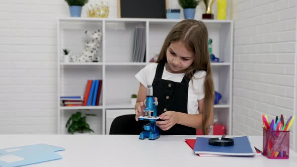 Busy Schoolgirl Using Microscope on Biology Lesson Education alt