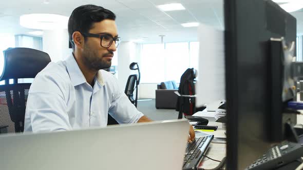 Male executive working on computer alt