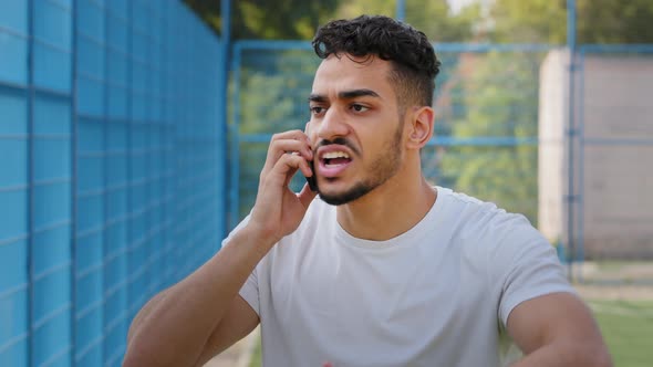 Angry Aggressive Annoyed Young Middle Eastern Arabic Athlete in Summer Sportswear Holding Smartphone alt