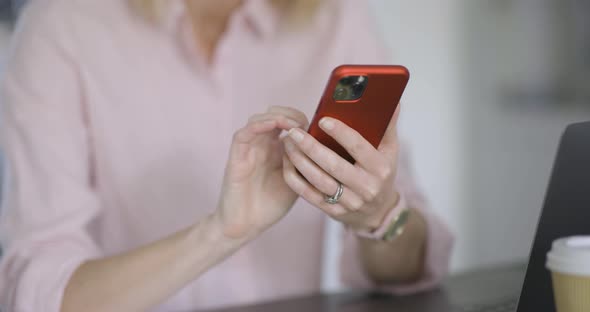 Hands of woman text messaging on smartphone