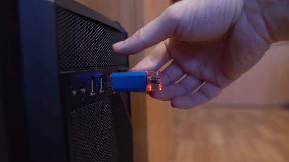 Man Pulls Out A Usb Flash Drive From A Computer Connector