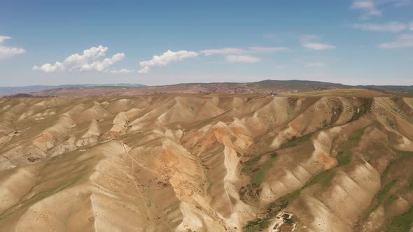Rolling mountains under blue sky and white clouds alt