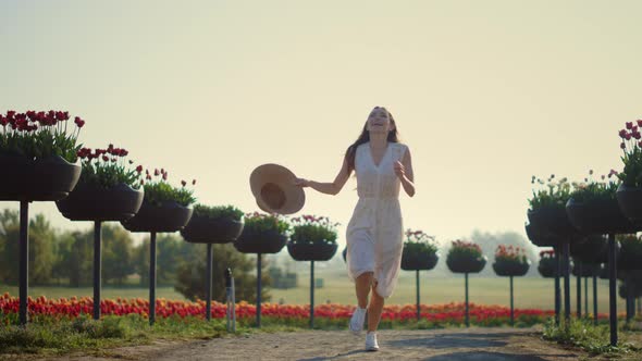 Young Woman Running in Park with Flowers alt