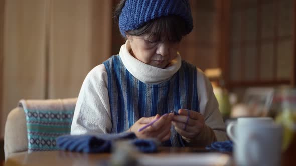 A woman knitting a neck warmer alt