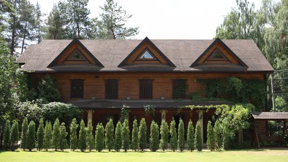 large wooden house with green area and trees in the garden