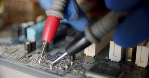 Repairman in Electronics Repair Service By Means of the Tester Checks Serviceability of the Device alt