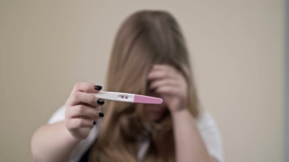 Teenage Girl Shows a Strip Test for Pregnancy