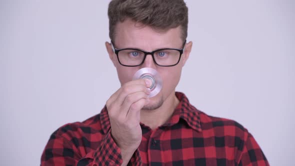 Face of Happy Bearded Hipster Man Playing with Fidget Spinner alt