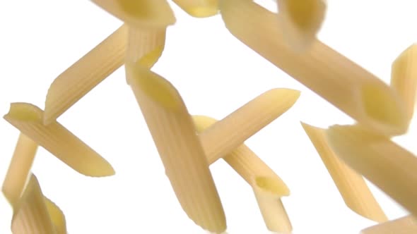 Dry Raw Pasta Penne Flying Diagonally on a White Background alt