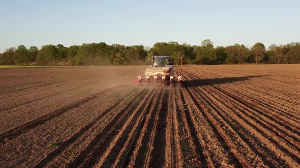 Tractor Working in Field at Sunset alt