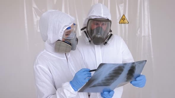 Medical Doctor with Protective Suit Checking Examining Chest Xray Film alt