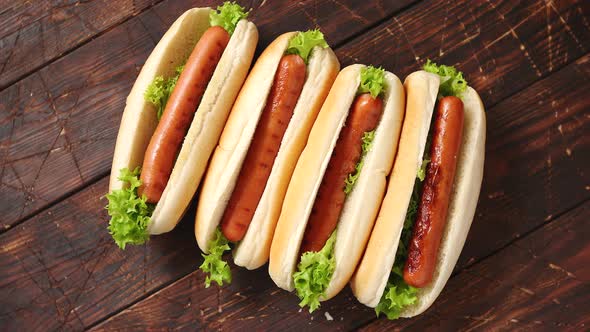 Tasty American Hot Dogs Assorted in Row. Placed on Wooden Table alt