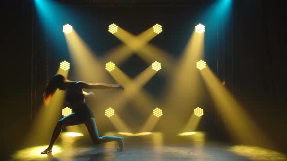 The Movement of a Graceful Woman in Black Lingerie, Practicing Contempt in the Dark of the Studio alt