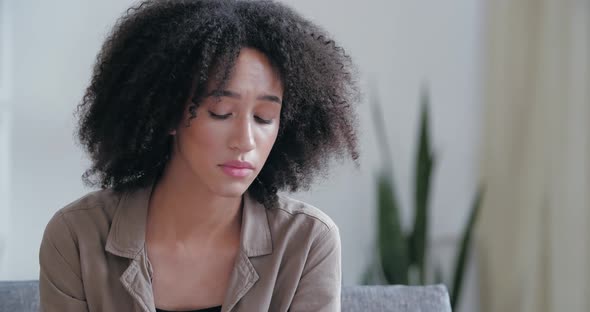 Young Upset Worried Stressed Young African Ethnicity Woman Sitting Sofa at Home Holding Documents alt