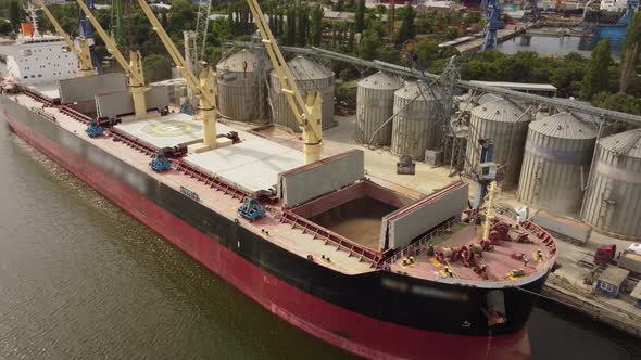Loading Grain Into Sea Cargo Vessel in Seaport From Silos of Grain Storage alt