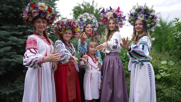 Group of Graceful Beautiful Ukrainian Women and Girl Standing in Park Looking at Camera Stretching alt