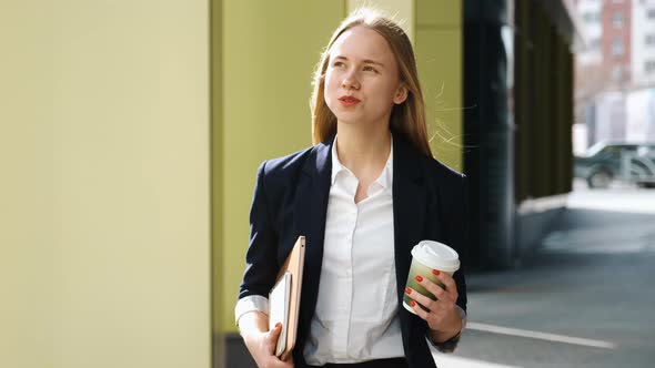 Confident Young Woman in Suite and White Shirt Walking in City Near Office