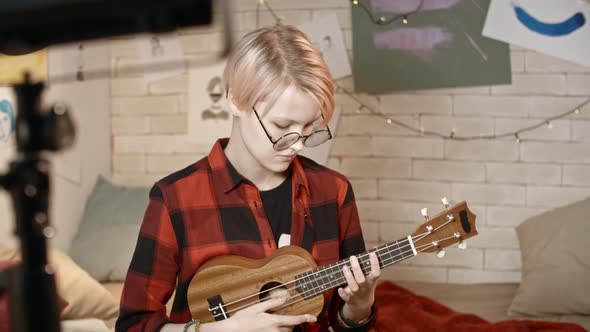 Teenage Girl Playing Ukulele on Camera alt