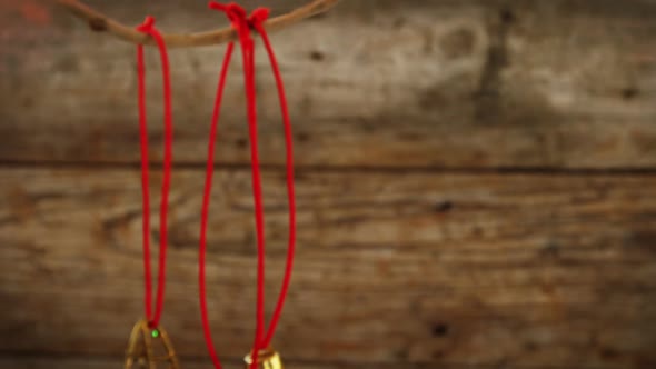 Star shape and small bells ornament hanging on a branch alt