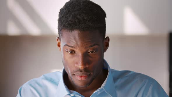Attractive young student in shirt reading news on laptop screen alt
