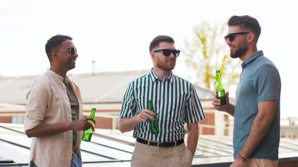 Happy Male Friends Drinking Beer at Rooftop Party alt