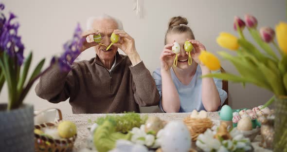 Happy Easter - Cheerful Grandfather and Granddaughter Play with Easter Eggs on Easter alt