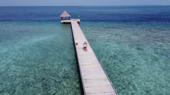 A Man and a Woman Couple Walking on Wooden Decking Bridge Holding Hands