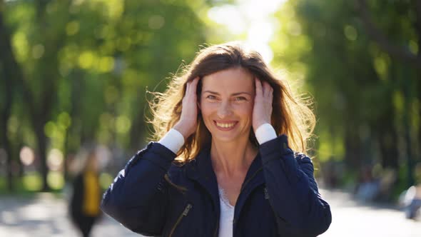 Happy Woman Walking in Park in Bright Sunshine