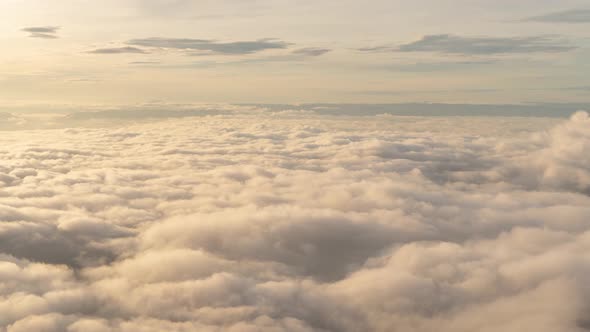 Time lapse of aerial view of sunset above fluffy sea fog misty clouds alt