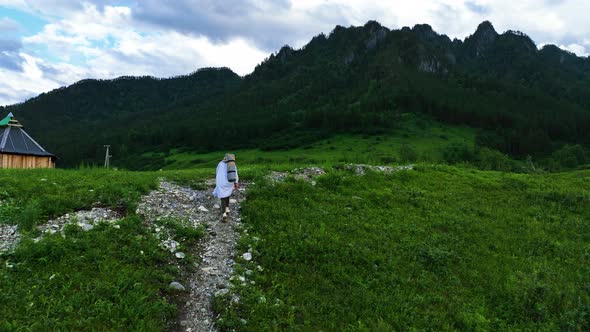 The girl walks in the mountains in summer time. Travels