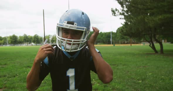 Football Player Putting On His Helmet