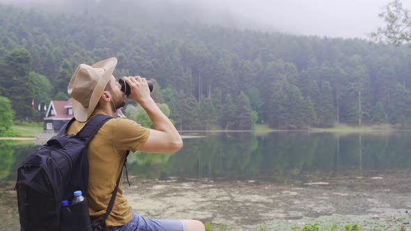 Free man is resting on the lake shore. alt