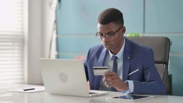 Young African Businessman Making Successful Online Payment on Laptop alt
