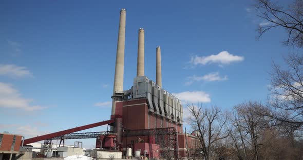 Coal burning power plant with three smoke stacks and clouds time-lapse video. alt