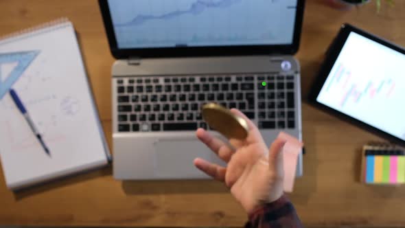 Man working in office is throwing bitcoin in hand in slow motion