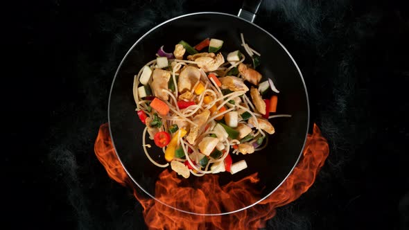 Super Slow Motion Shot of Throwing Noodle Mixture on Frying Pan and Fire Blast at 1000Fps alt