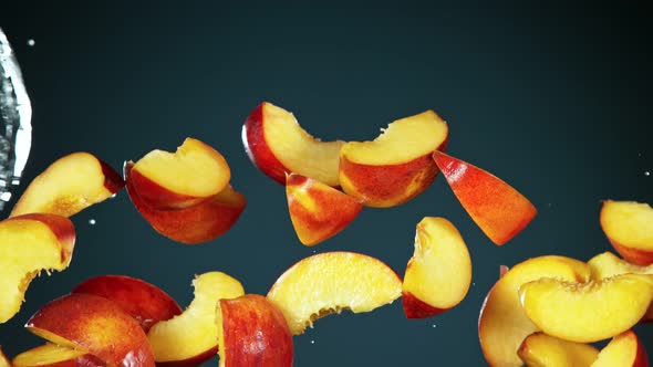 Super Slow Motion Shot of Flying Fresh Peach Slices and Water Side Splash at 1000Fps alt