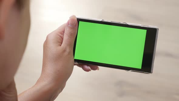 Younger  woman holds greenscreen  smart phone 4K 2160p 30fps UltraHD footage -  Green screen tablet 