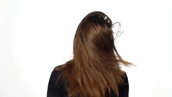 Graceful model with gorgeous hair poses for the camera in the studio on a white background. alt