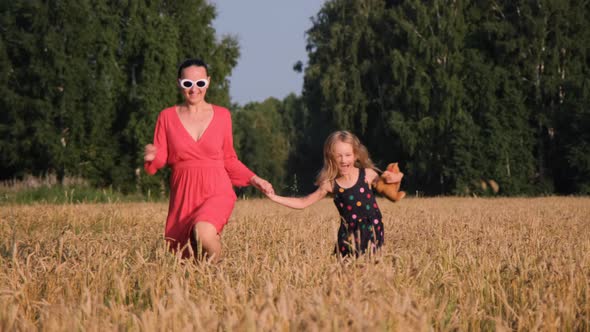 Mother with Daughter Running in a Wheat Field alt