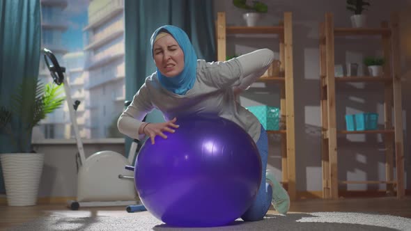 Portrait Muslim Woman on a Fitness Ball Injury and Back Pain alt
