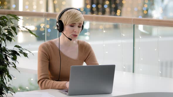 Middle Aged Adult 40s Business Woman in Headset Microphone Talking at Laptop Web Camera Consultation alt