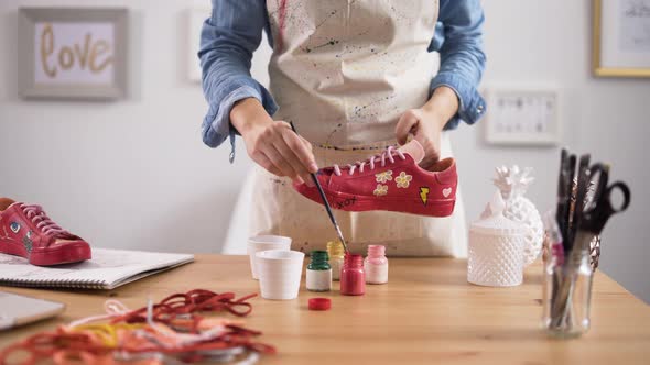 Entrepreneur Customizing Pair of Sneakers in Arts and Crafts Workshop alt