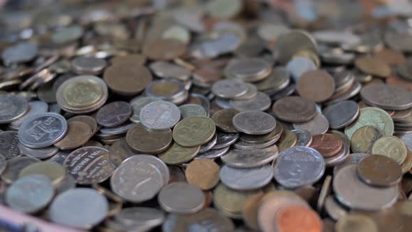 Male hand takes handful of coins from money pile close up alt