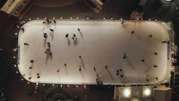 People Are Skating on Ice Rink in the Evening, Aerial Vertical Top-down View
